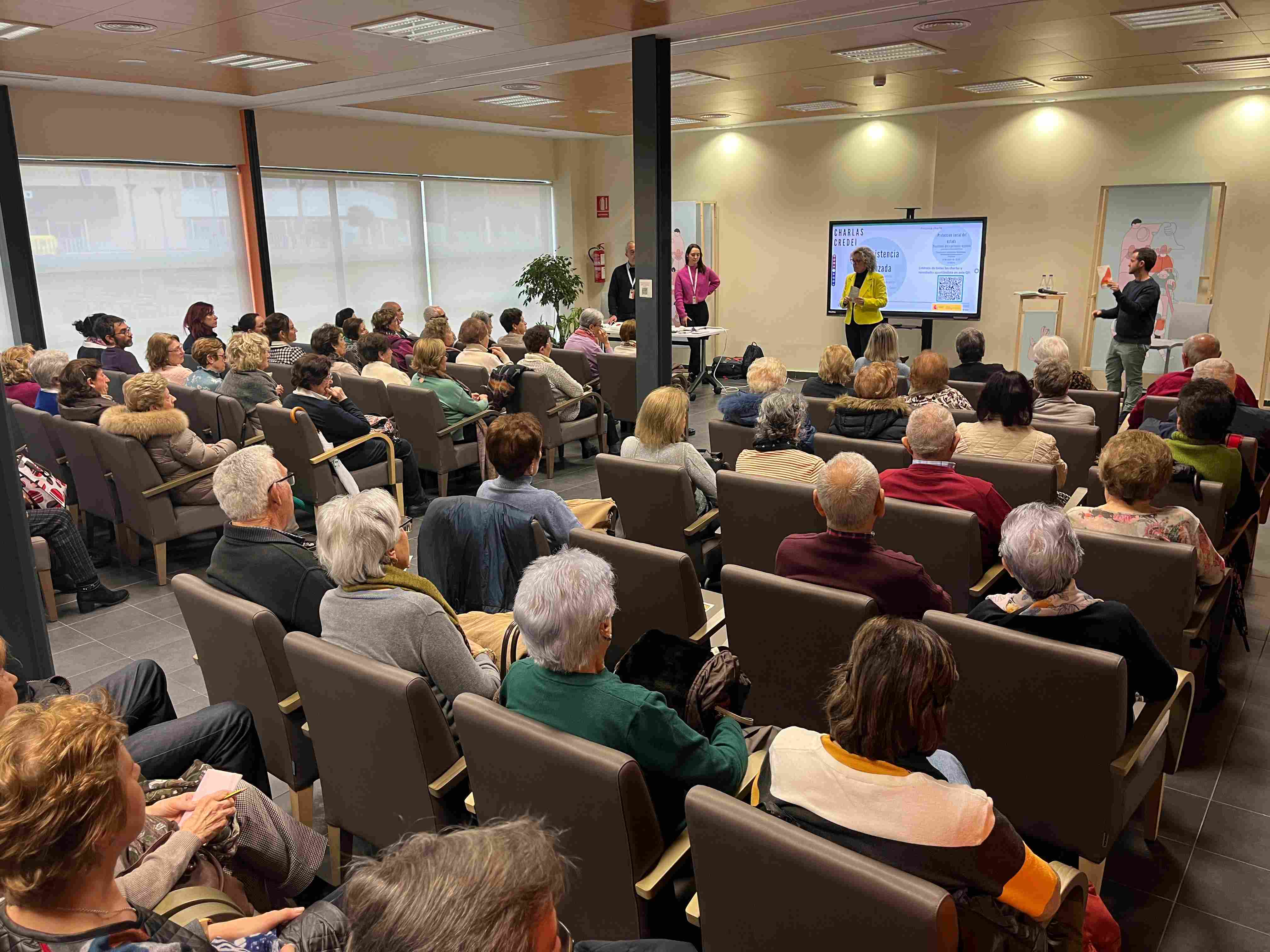 Personas asistentes a la charla sobre teleasistencia avanzada atienden las explicaciones del personal.